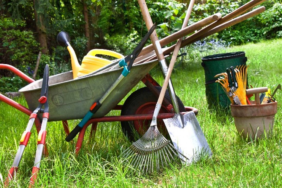 Schubkarre auf Rasen mit vielen Werkzeugen